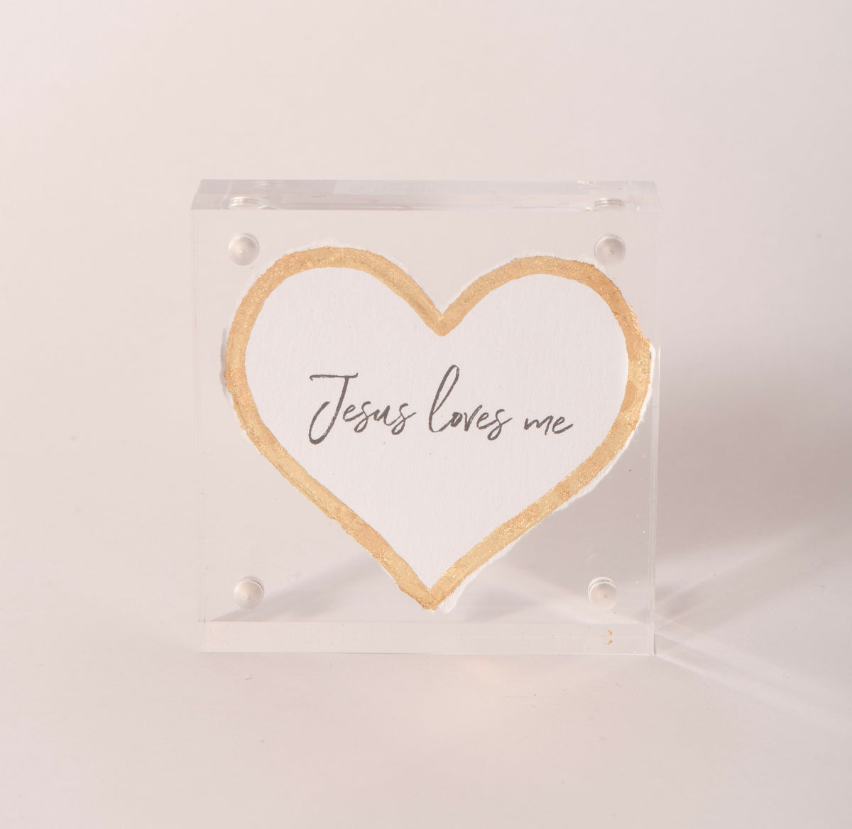 Clear acrylic keepsake with a gold-embossed "Jesus Loves Me" heart, sold at Thistles in Pella, Iowa